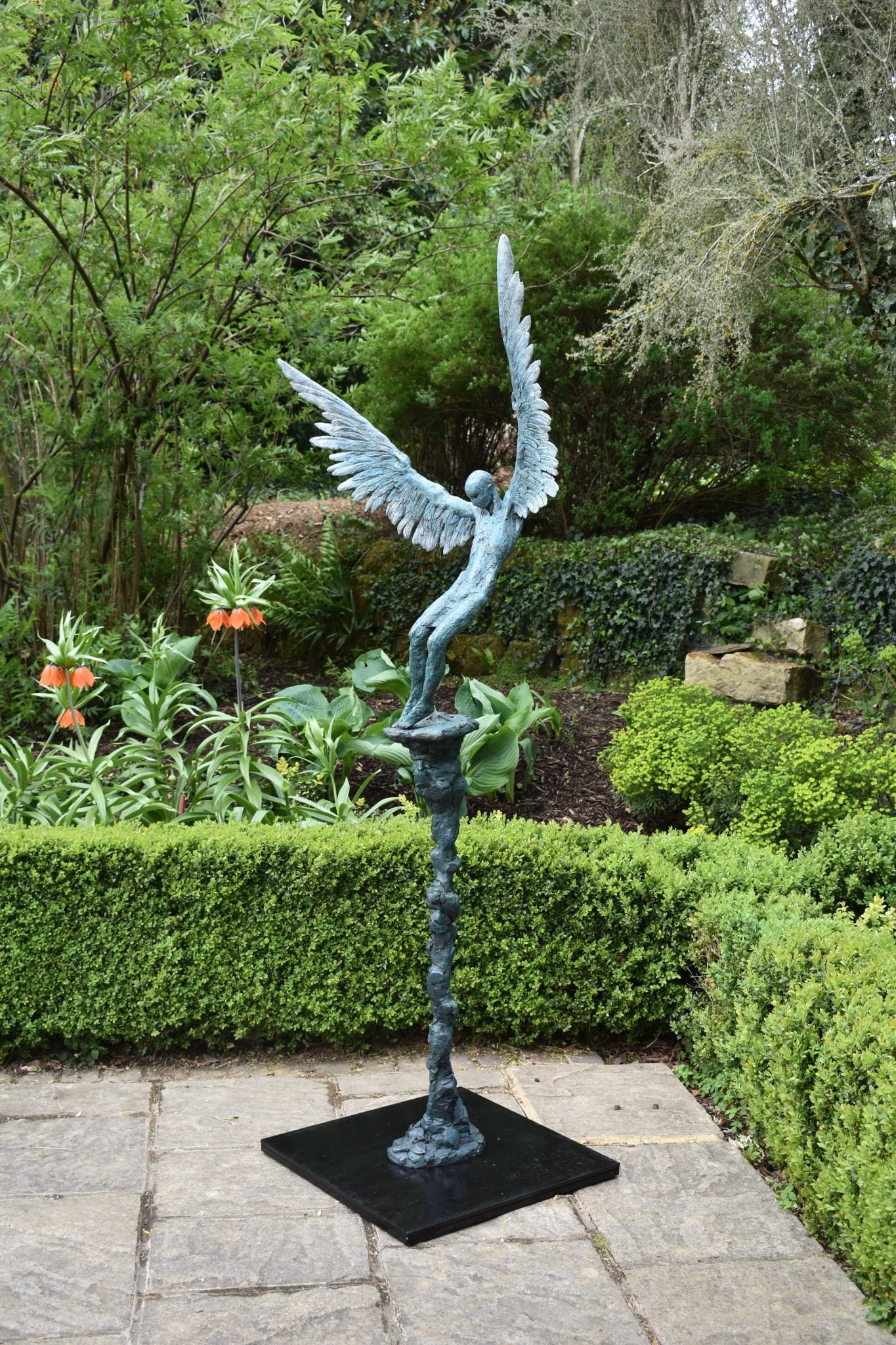 Sculpture in bronze of the mythological figure of Icarus falling from the sky, standing in a courtyard
