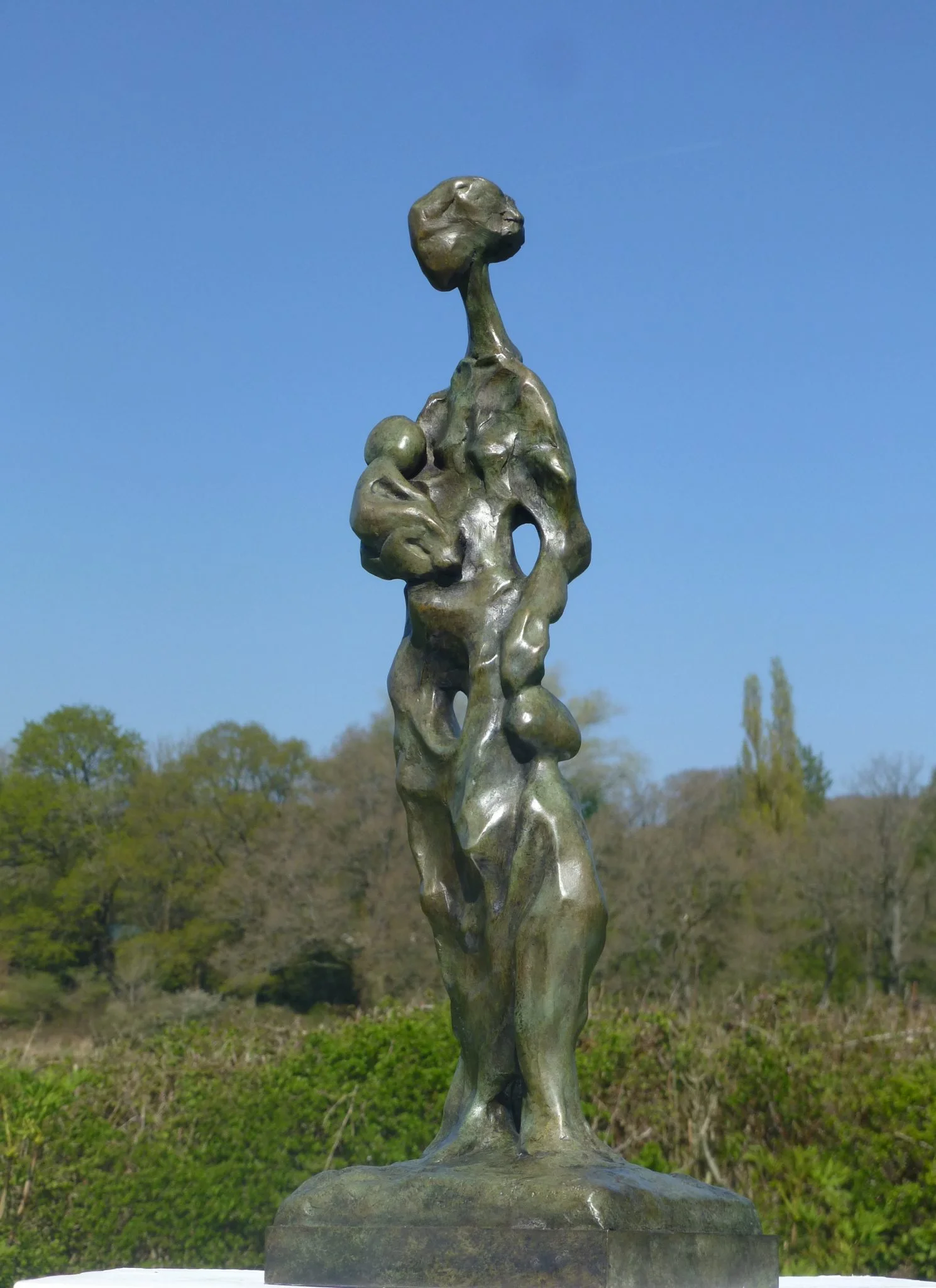 Abstract bronze sculpture of a mother with a baby and a small child