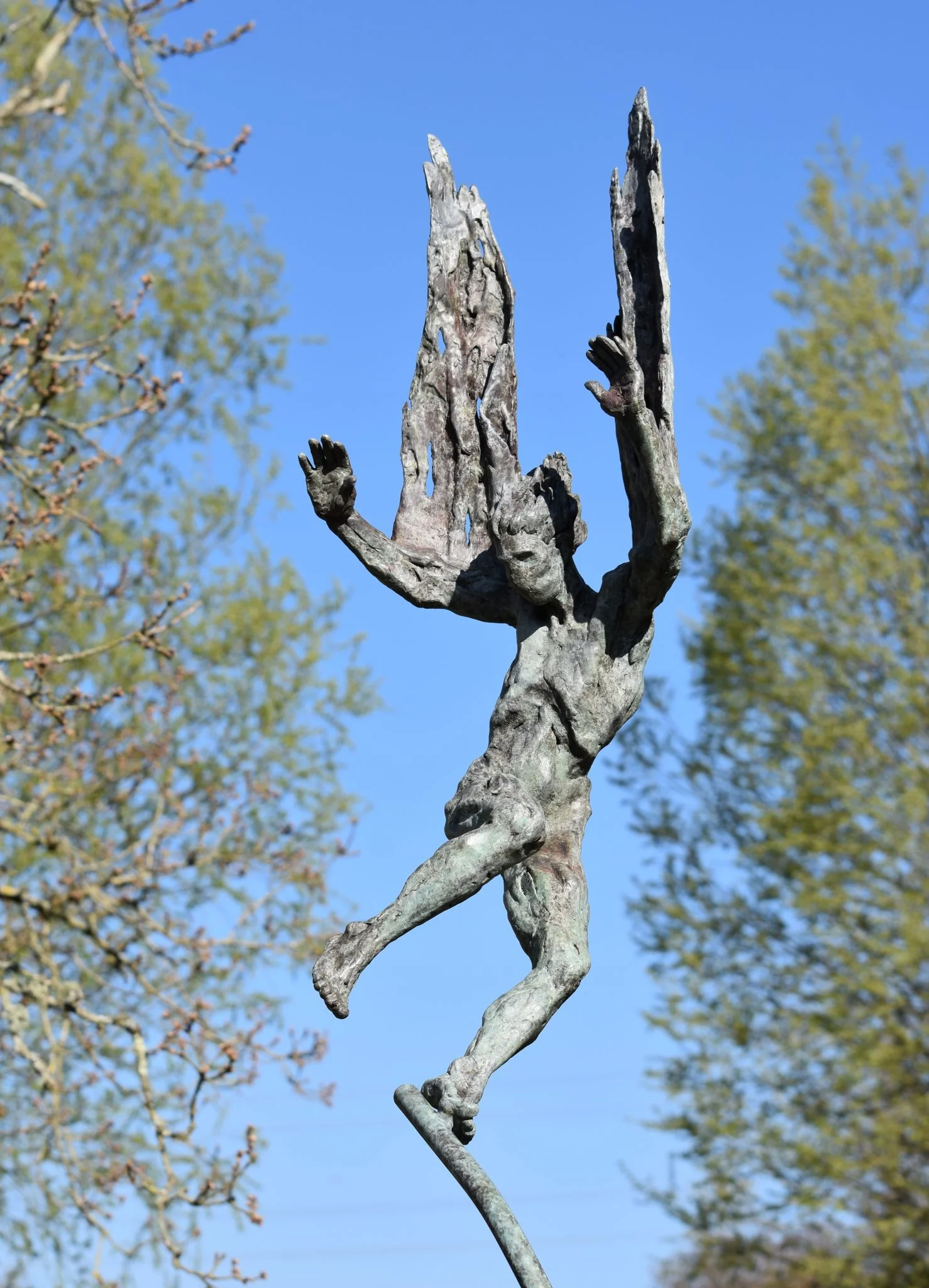 A bronze sculpture of Icarus falling from the sky