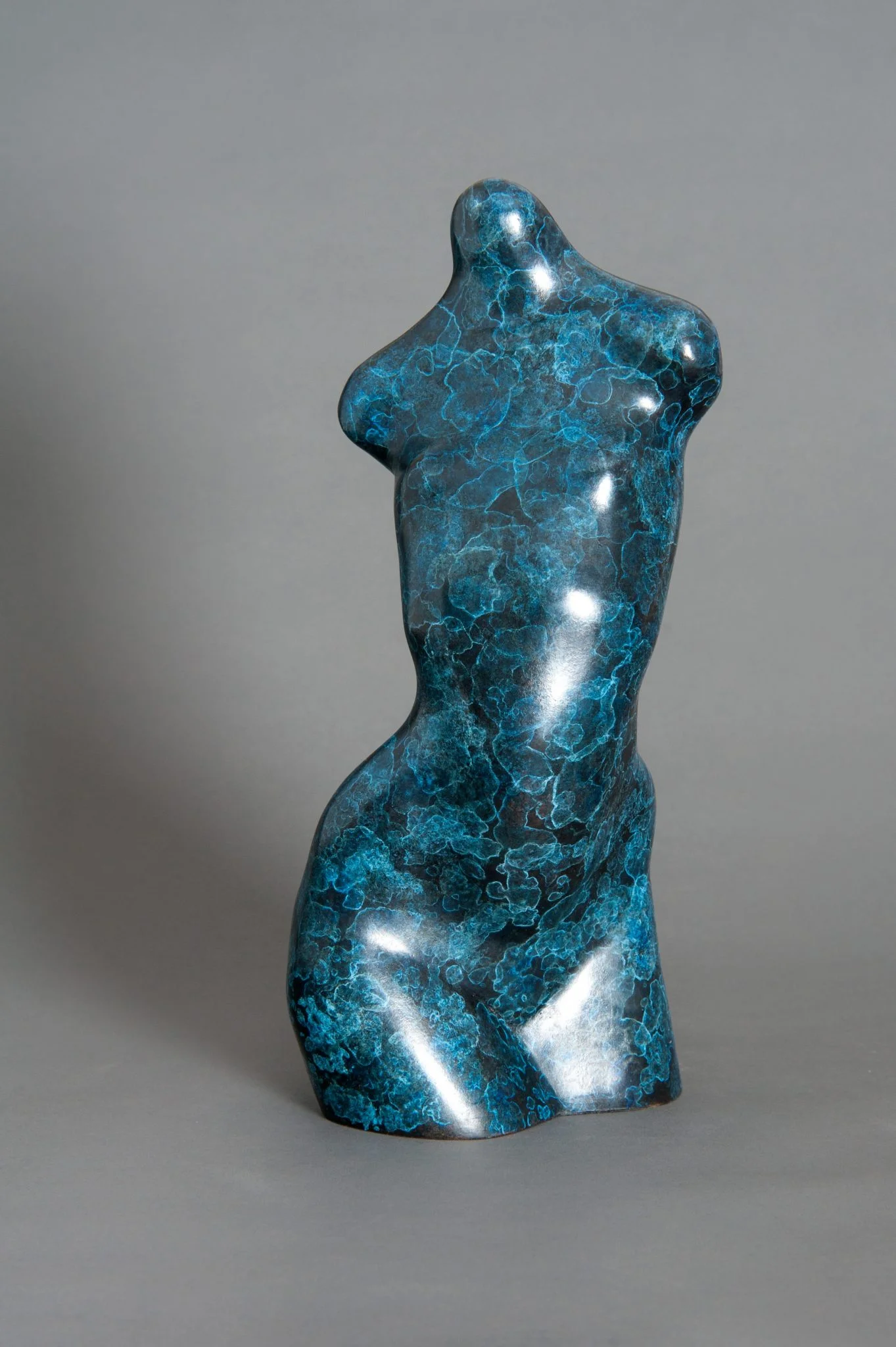 Sculpture of a human torso in bronze with a unique blue patina